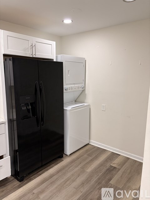 A black fridge and a white dishwasher in a kitchen.