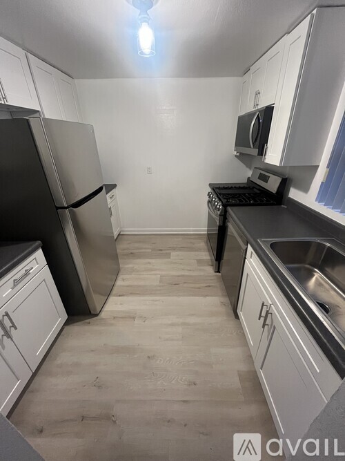 A kitchen with black appliances and white cabinets.