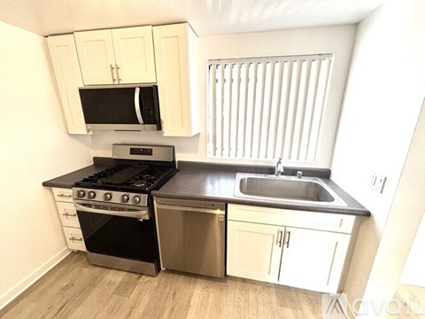 A kitchen with white cabinets and a black stove top oven.