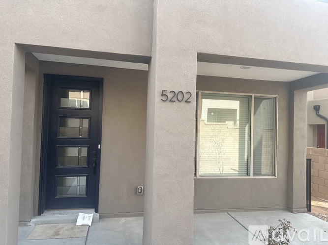 The image shows the front of a house with the number 5202 on the wall.