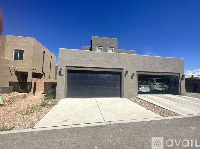 A modern house with a large garage door and a car parked inside.