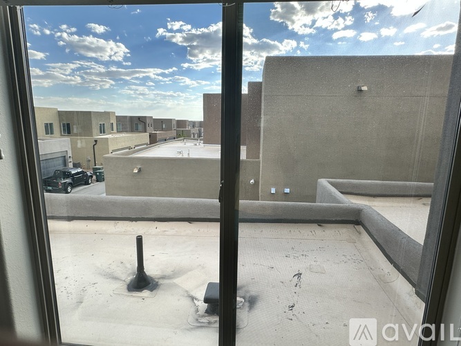 A view from a window looking out at a parking lot and buildings.