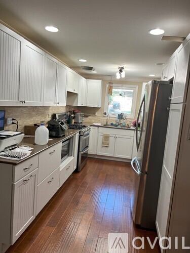 A kitchen with white cabinets and a wooden floor.