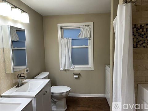 A kitchen with white cabinets and a wooden floor.
