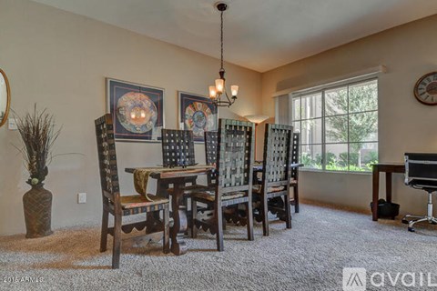A dining room with a table and chairs.