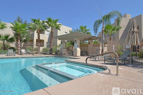 A pool surrounded by palm trees and a building.