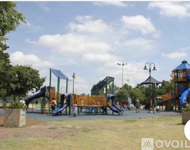 A playground with a blue slide and a wooden structure.