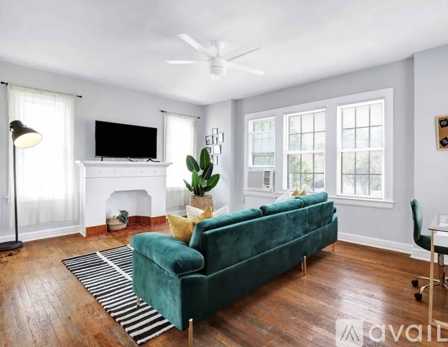 A living room with a green couch and a fireplace.