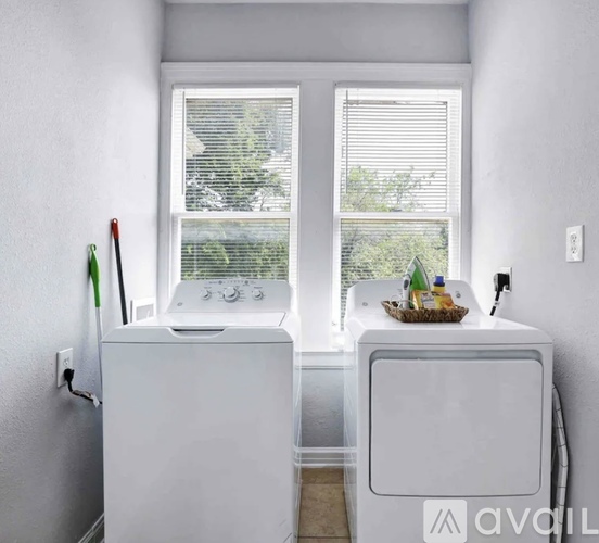 A white refrigerator and freezer are in a kitchen with a window in the background.