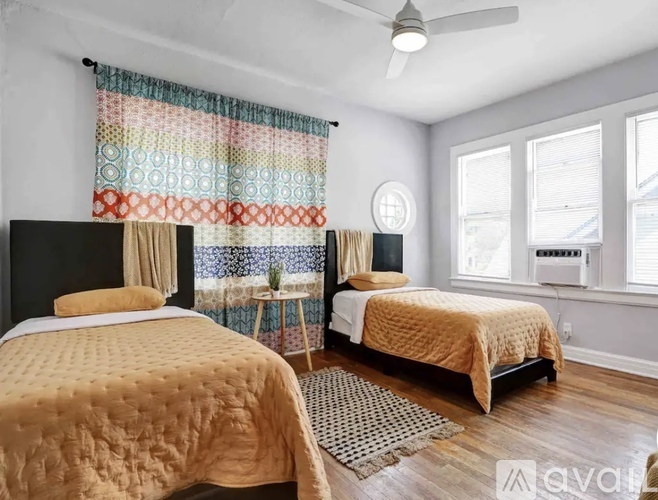 A bedroom with two beds and a ceiling fan.