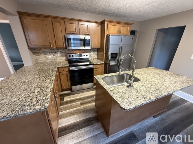 A kitchen with granite countertops and wooden cabinets.