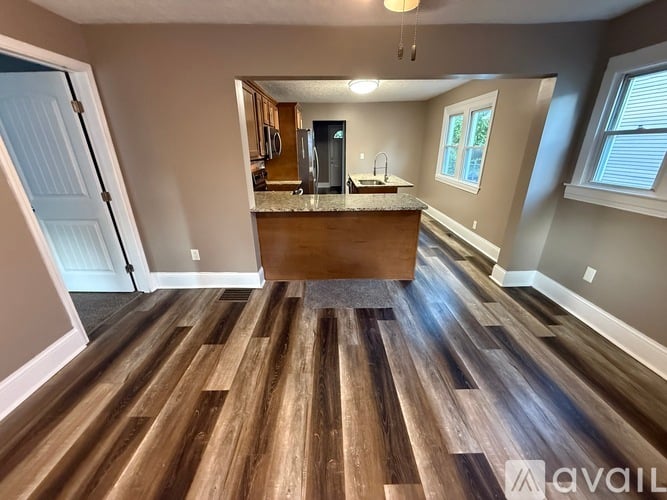 A kitchen with a wooden floor and a counter with a sink.