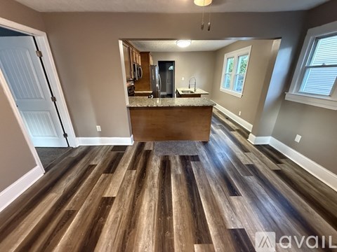 A kitchen with a wooden floor and a counter with a sink.