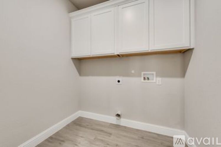 A room with white cabinets and a light switch.