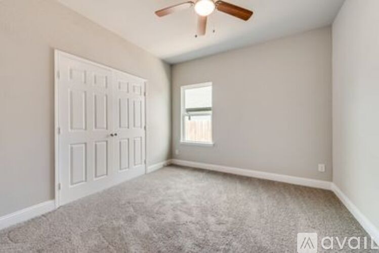 A room with a white door and a window with a view of a building outside.