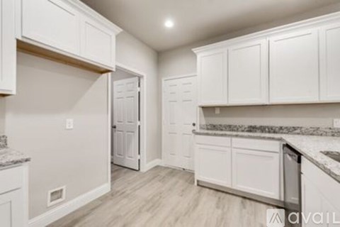 A kitchen with white cabinets and a granite countertop.