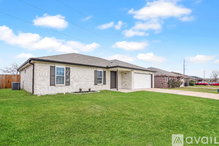 A house with a white brick exterior and a grey roof is for sale.
