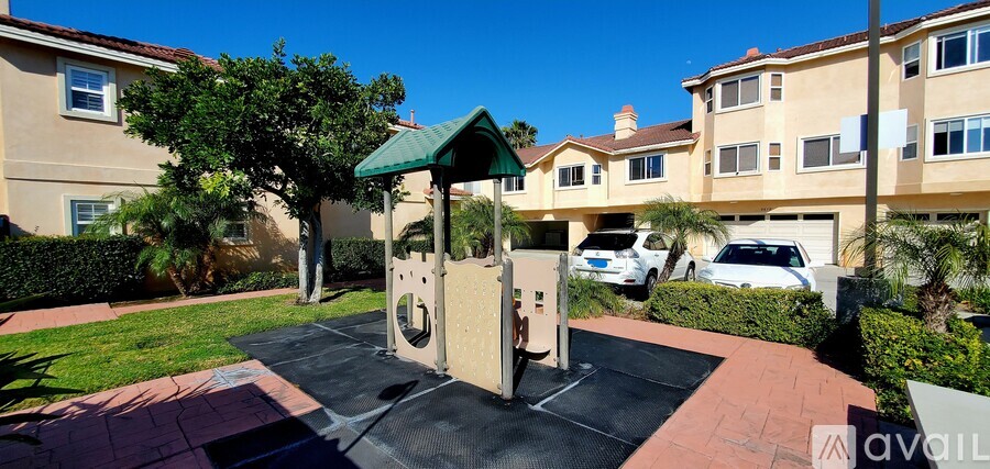 A playground with a slide and swings in a residential area.