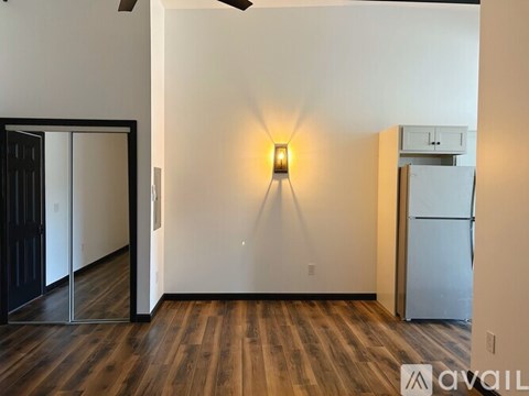 A room with a wooden floor and a wall-mounted light fixture.