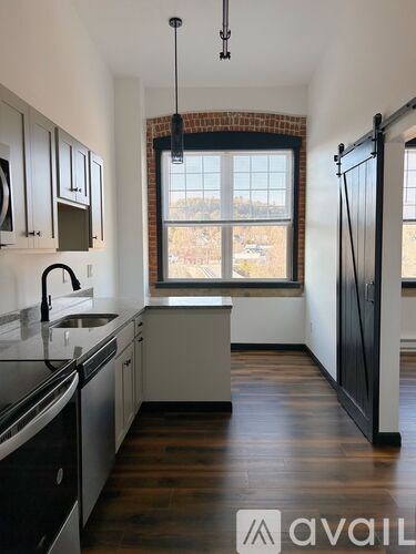 A kitchen with a window and wooden floors.