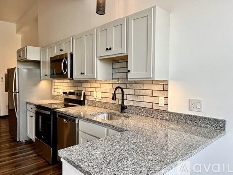 A kitchen with granite countertops and white cabinets.