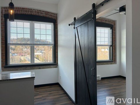 A room with a sliding door and a window overlooking a street.
