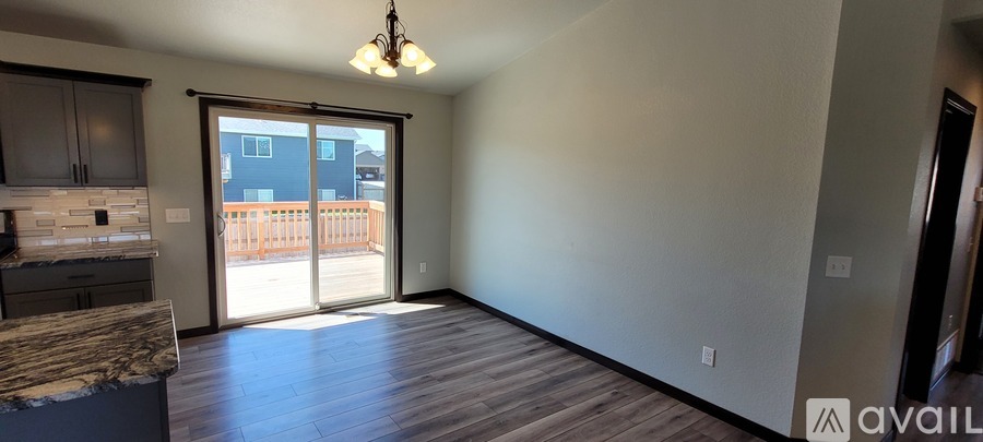 A room with a marble countertop and a sliding glass door leading to a balcony.