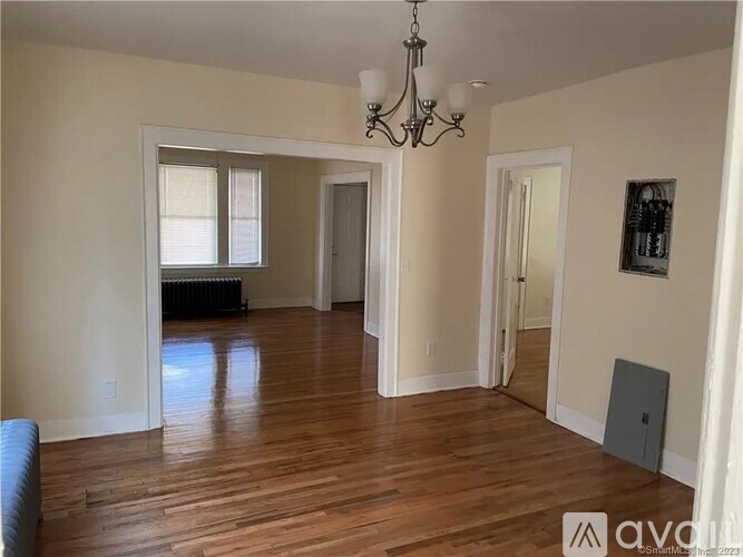 A room with wooden floors and a chandelier.