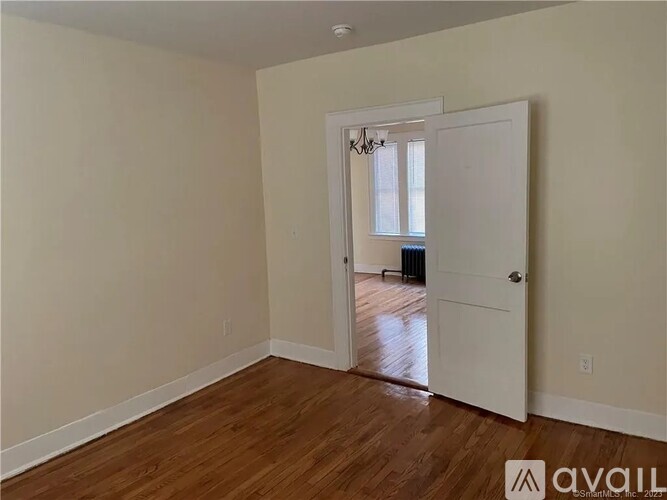 A room with a white door and a chandelier.