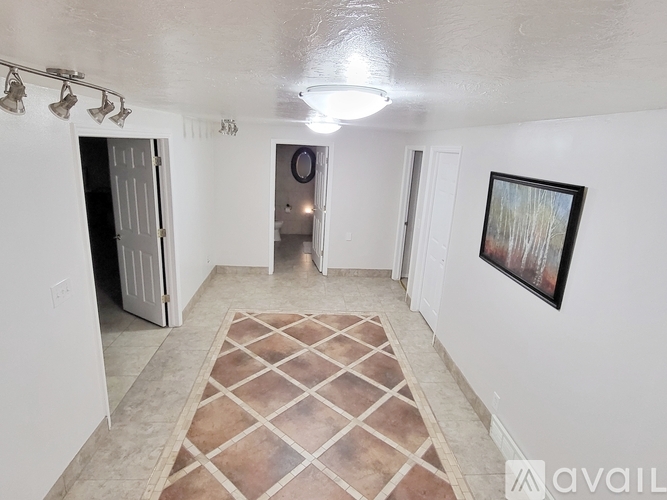 A room with a rug on the floor and a painting on the wall.