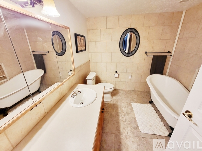 A bathroom with a tub, toilet, and sink.