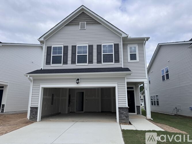 A two-story house with a garage is available for sale.