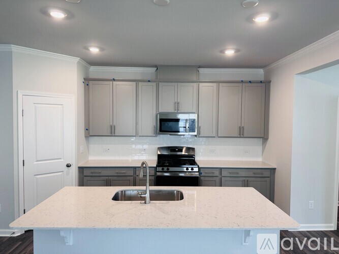 A kitchen with a marble countertop and stainless steel appliances.