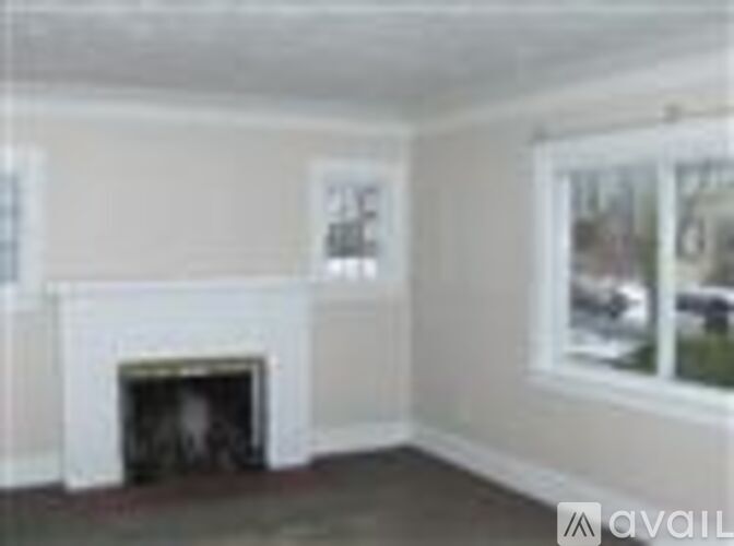 A room with a fireplace and a window.