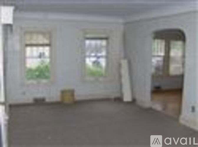 A room with a large window and a door on the right side.
