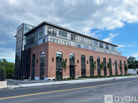 A modern building with a glass facade and a brick section is available for rent.