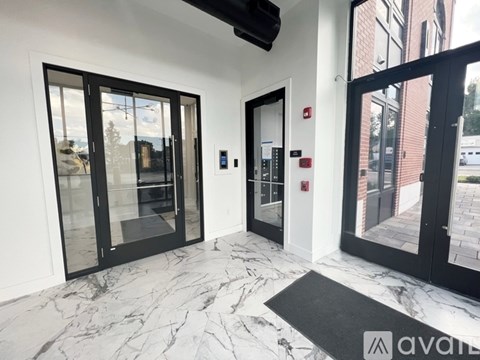 A hallway with marble floors and black doors.