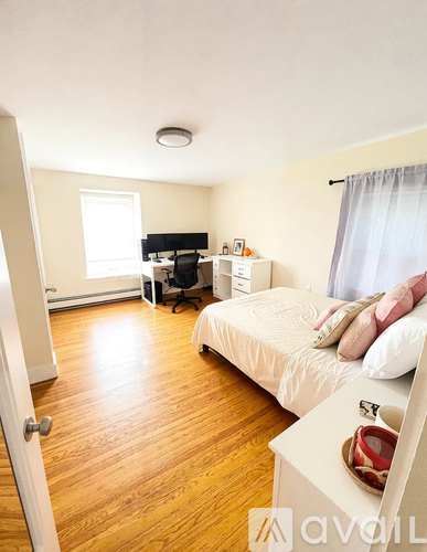 A bedroom with a bed, desk, and chair.