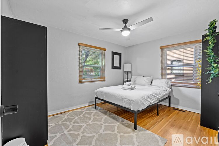 A bedroom with a bed, a ceiling fan, and a rug.