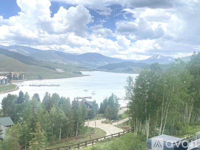 A scenic view of a lake surrounded by mountains and trees.