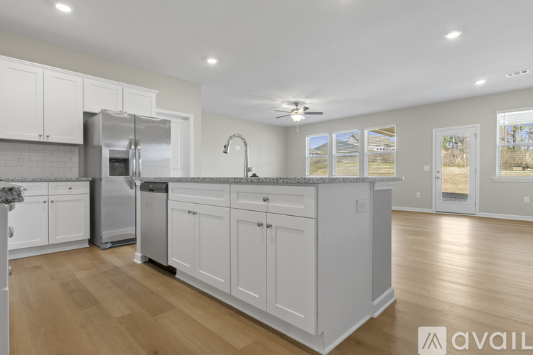 A kitchen with white cabinets and a wooden floor.