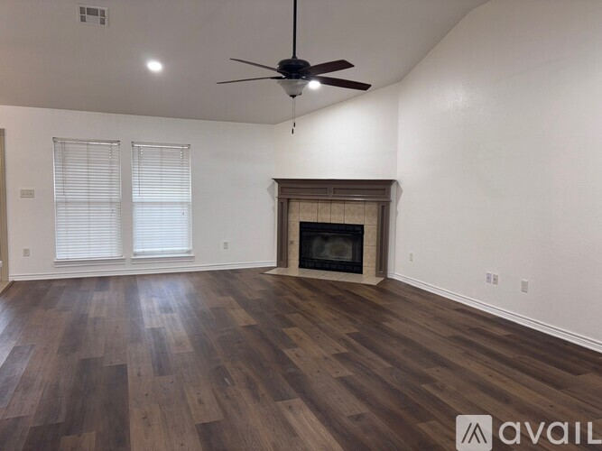A room with a fireplace and a fan on the ceiling.