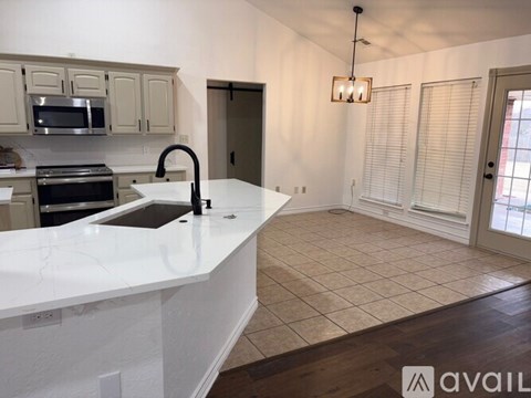 A kitchen with a white countertop and a microwave above it.