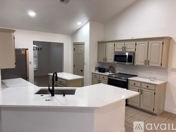 A kitchen with a white countertop and beige cabinets.
