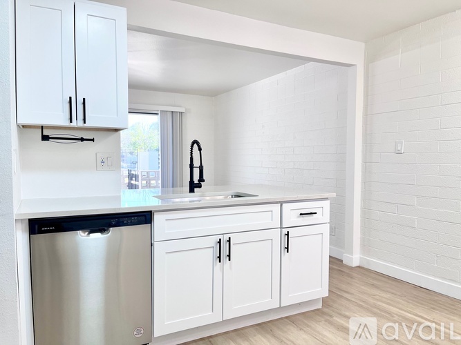 A kitchen with white cabinets and a stainless steel dishwasher.