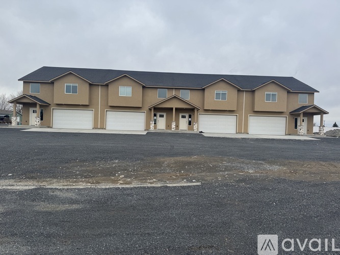 A large, multi-level house with a black roof and beige walls is available for purchase.