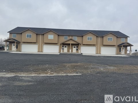 A large, multi-level house with a black roof and beige walls is available for purchase.