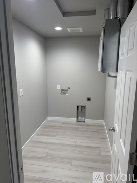 A hallway with a wooden floor and white walls.