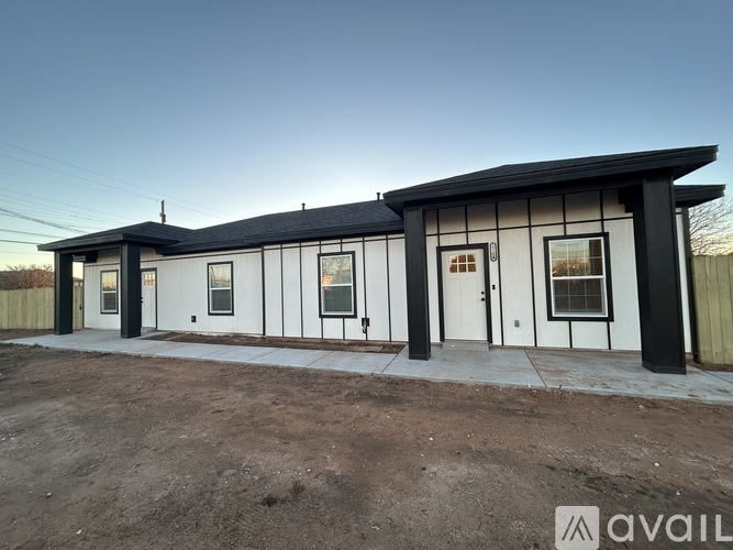 A modern house with a black roof and white walls is available for purchase.