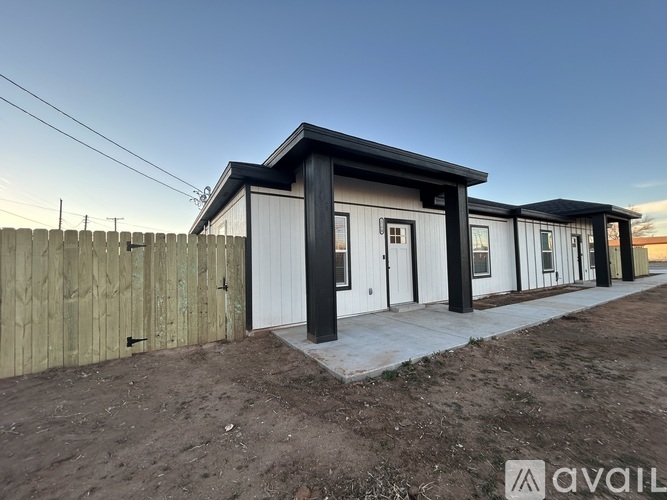 A row of modern houses with a wooden fence in the foreground.
